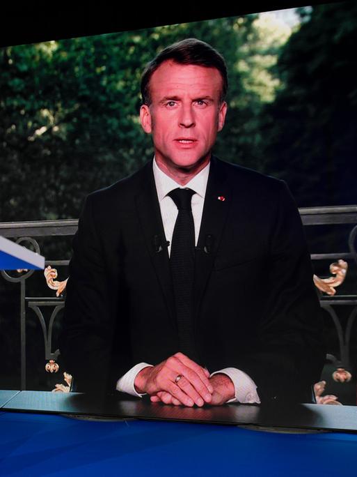 Der französische Präsident Emmanuel Macron auf einem Fernsehbildschirm.