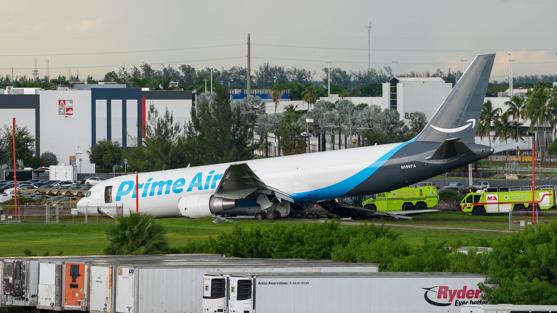 Ein Flugzeug mit der Aufschrift "Prime Air" liegt am Unfallort am Miami International Airport. Zwei Einsatzfahrzeuge stehen daneben. Ein Flugzeug mit der Aufschrift "Prime Air" liegt am Unfallort am Miami International Airport. Zwei Einsatzfahrzeuge stehen daneben.