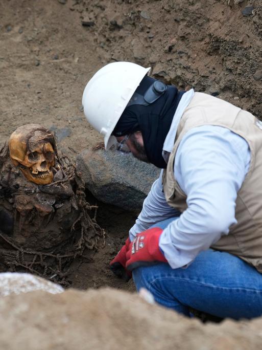 Ein Archäologe gräbt eine Mumie in Peru aus