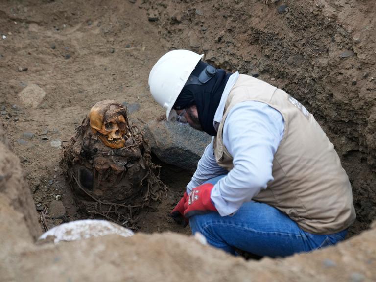Ein Archäologe gräbt eine Mumie in Peru aus