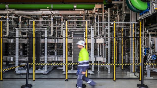 Ein Mann mit Schutzhelm läuft durch eine Wasserstofffabrik