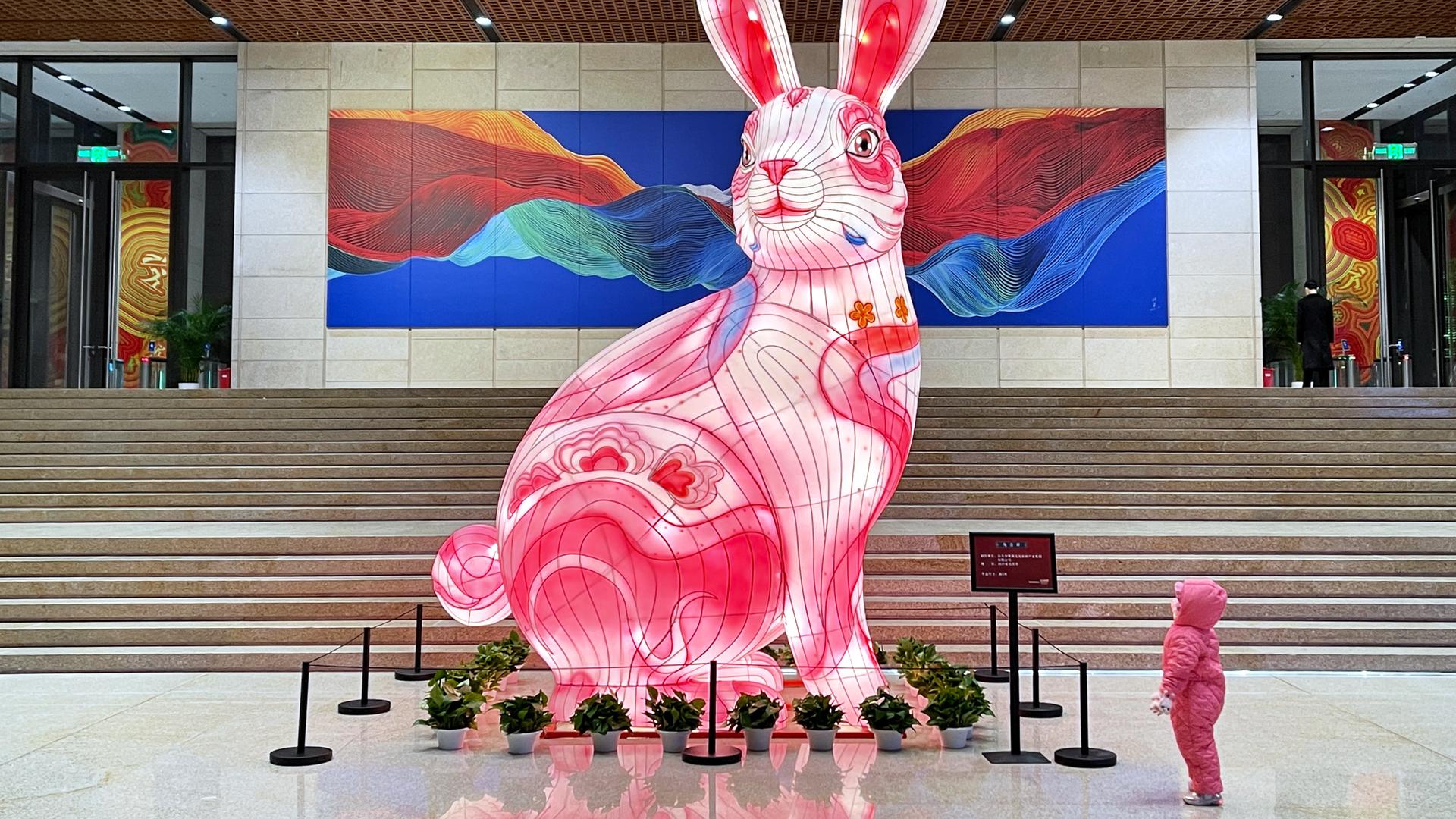 Ein Kind betrachtet einen riesigen leuchtenden Hasen im China National Arts and Crafts Museum in Peking.
