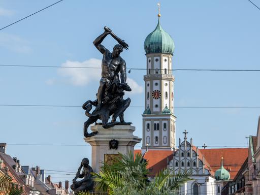 Die Brunnenstatue des Herkules in der Maximilianstraße vor der Basilika Sankt Ulrich und Afra in Augsburg 
