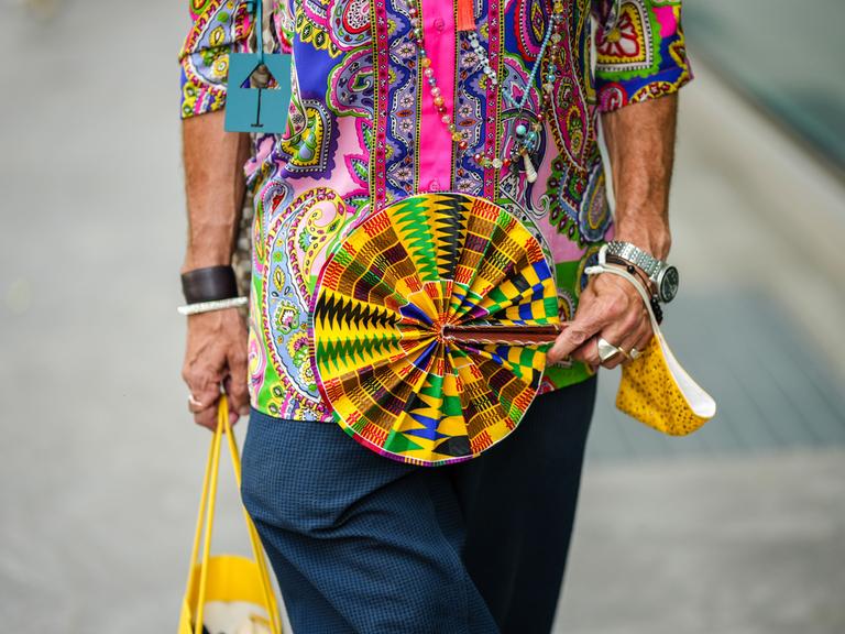 Street Style: Ein Mann mit buntem Fächer auf der Fashion Week in Mailand, 2022.