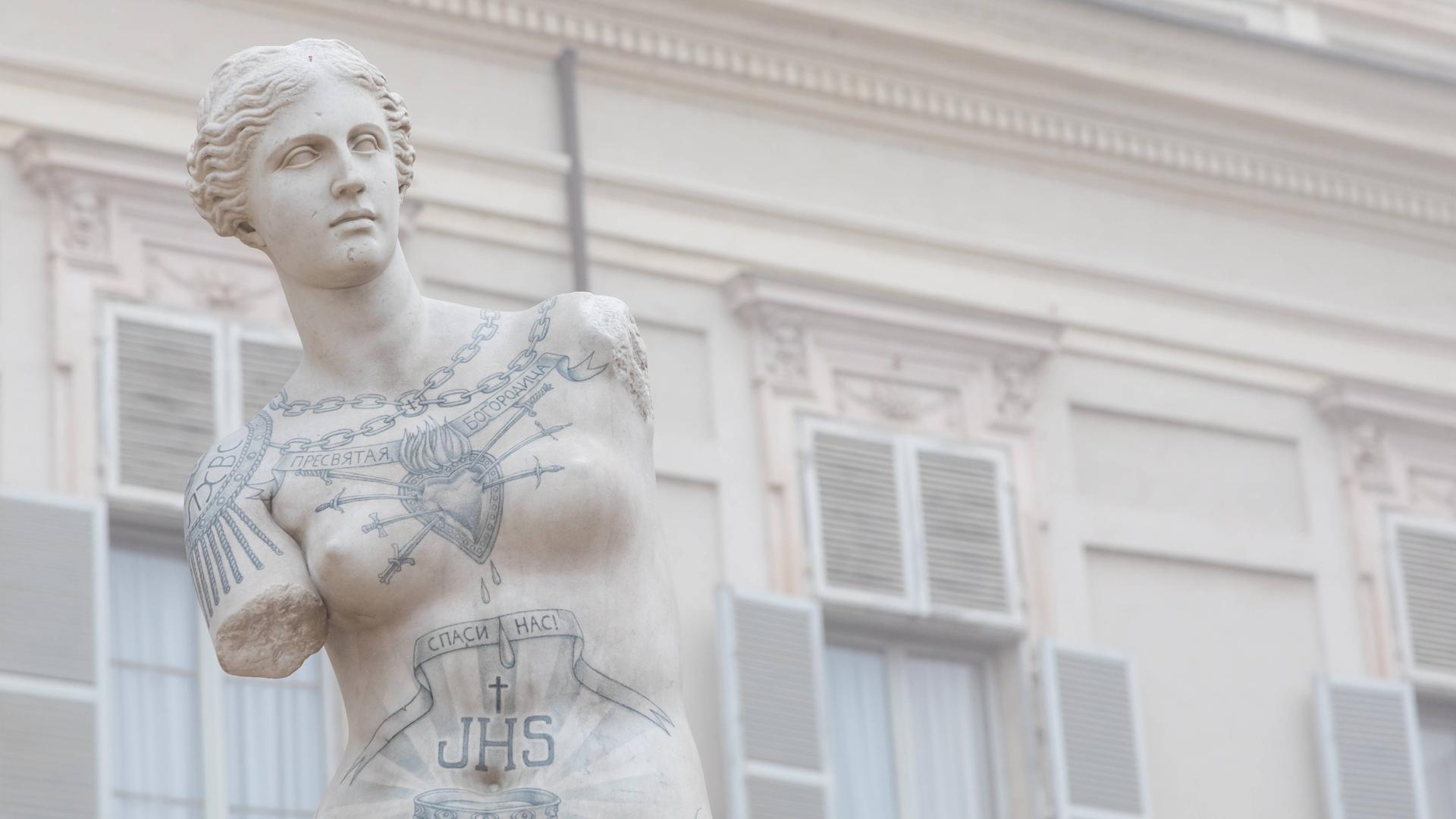 Eine Statue der Venus von Milo ist mit Tattoos bemalt.