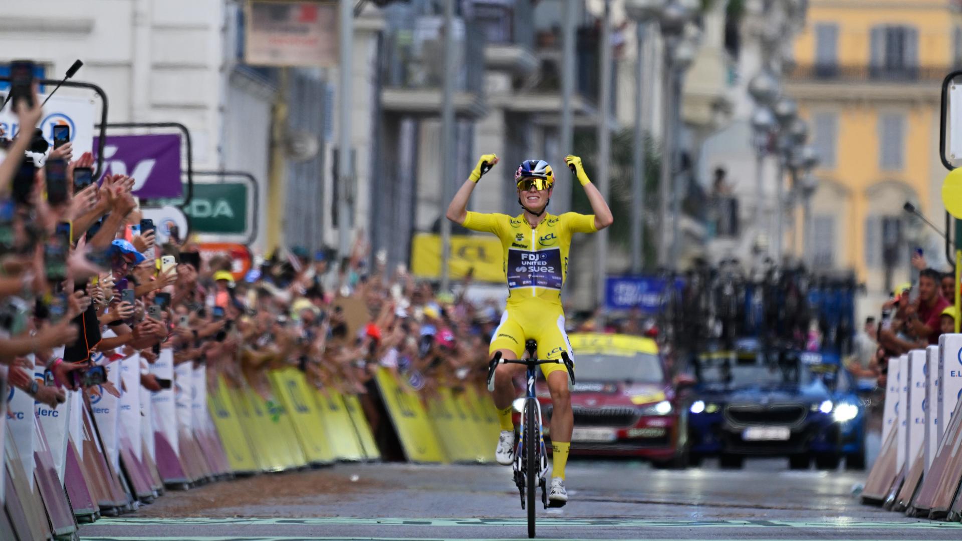 Demi Vollering feiert auf der Ziellinie ihren Sieg bei der Tour. Sie trägt das gelbe Trikot und hat die Arme nach oben gereckt. Demi Vollering feiert auf der Ziellinie ihren Sieg bei der Tour. Sie trägt das gelbe Trikot und hat die Arme nach oben gereckt.
