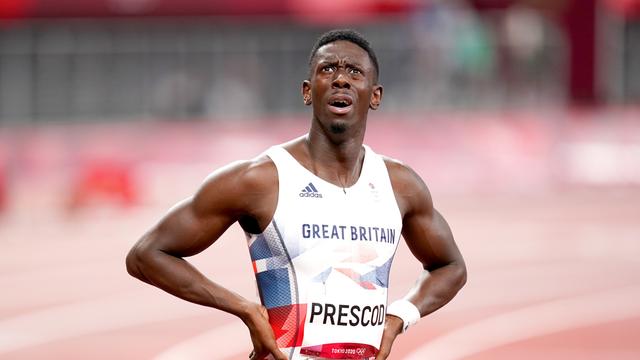 Ein Sprinter im Trikot von Großbritannien steht auf der Laufbahn, die Hände in den Hüften, und schaut nach oben.