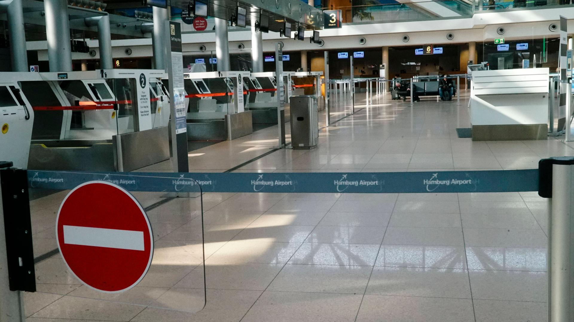 Eine Reihe von Schaltern am Flughafen in Hamburg. Im Vordergrund ist ein Durchgang-Verboten-Schild. Die Halle ist leer. Es ist kein Mensch zu sehen.