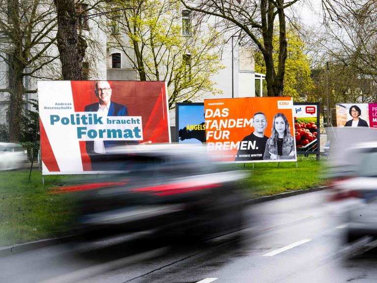 Wahlplakate verschiedener Parteien stehen an einer Straße in Bremen.