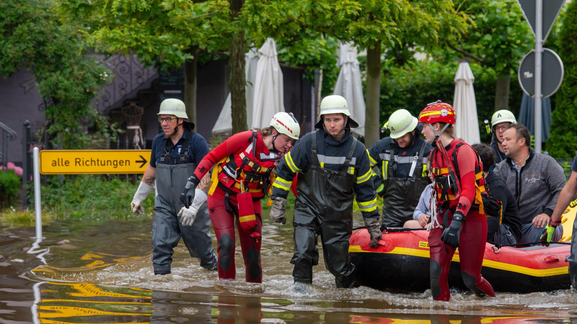 Mit einem Schlauchboot holen Feuerwehr und Wasserretter Anwohner aus ihren überfluteten Häusern. Mit einem Schlauchboot holen Feuerwehr und Wasserretter Anwohner aus ihren überfluteten Häusern.