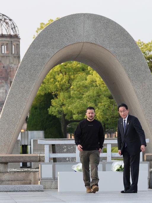 Japans Premierminister Fumio Kishida (r.) und der ukrainische Präsident Wolodymyr Selenskyj stehen vor dem Kenotaph für die Opfer der Atombombe im Friedenspark Hiroshima.