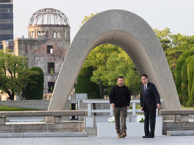 Japans Premierminister Fumio Kishida (r.) und der ukrainische Präsident Wolodymyr Selenskyj stehen vor dem Kenotaph für die Opfer der Atombombe im Friedenspark Hiroshima.