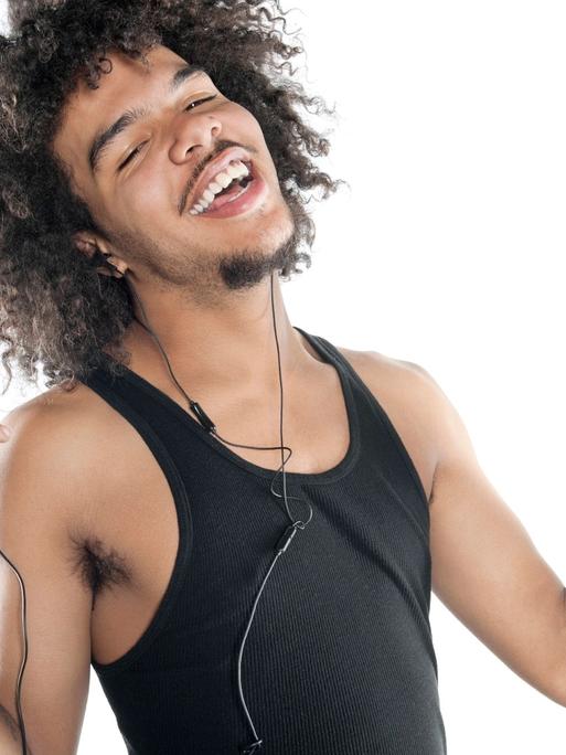 Portrait of a happy young man gesturing while listening to mp3 player over white background, model released, , 10138554.jpg, 20-24 Years, 20s Adult, Adult, Audio Equipment, Connection, Curly Hair, Cutout, Enjoyment, Front View, Fun, Gesturing, Half-Length, Happiness, Headphones, Holding, Leisure, Listening, Looking At Camera, Male, Men, Mp3 Player, Music, One, One Person, People, Portability, Portrait, Smiling, Standing, Studio Shot, Technology, Trendy, Vest, White Background, Young Adult, Young Adult Man,