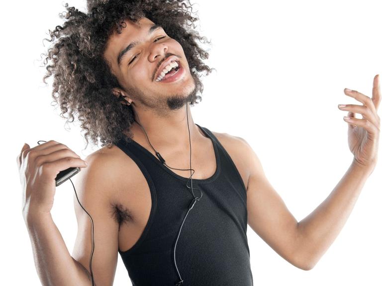 Portrait of a happy young man gesturing while listening to mp3 player over white background, model released, , 10138554.jpg, 20-24 Years, 20s Adult, Adult, Audio Equipment, Connection, Curly Hair, Cutout, Enjoyment, Front View, Fun, Gesturing, Half-Length, Happiness, Headphones, Holding, Leisure, Listening, Looking At Camera, Male, Men, Mp3 Player, Music, One, One Person, People, Portability, Portrait, Smiling, Standing, Studio Shot, Technology, Trendy, Vest, White Background, Young Adult, Young Adult Man,