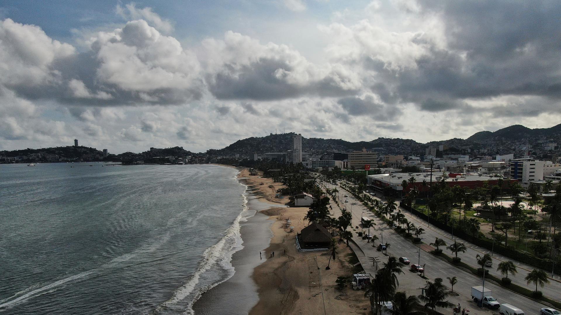 Touristen schlendern vor dem Eintreffen des Hurrikans "Erick" in Acapulco, Mexiko, am Strand entlang. Touristen schlendern vor dem Eintreffen des Hurrikans "Erick" in Acapulco, Mexiko, am Strand entlang.