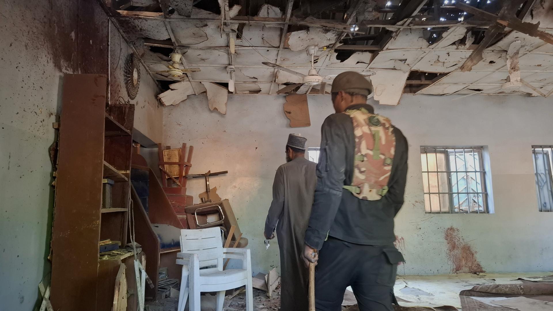 Menschen inspizieren den Ort einer tödlichen Bombenexplosion in einer Moschee in Maiduguri.