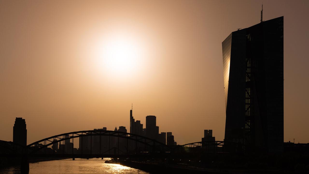 Die Sonne steht hoch über der Europäischen Zentralbank (EZB) und der Frankfurter Bankenskyline.