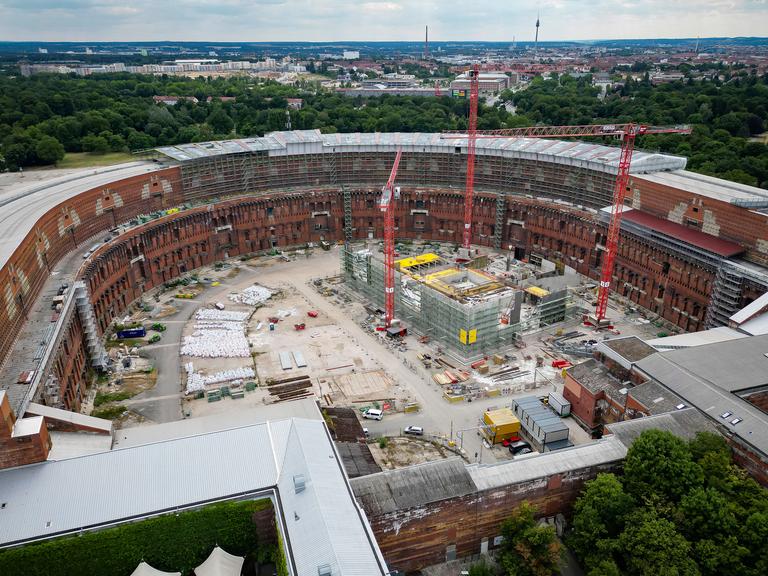 Im Innenhof der Kongresshalle Nürnberg wird eine Theaterspielstätte gebaut. Auf der Baustelle stehen mehrere Kräne.
