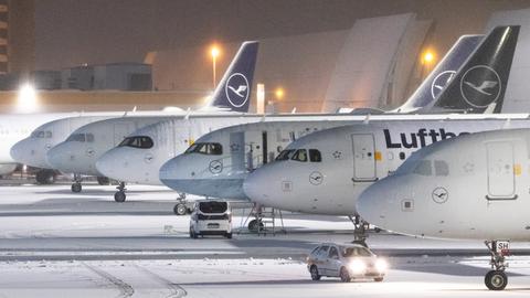 Mehrere Flugzeuge der Lufthansa stehen teils mit Schnee bedeckt auf dem Flughafen Frankfurt.