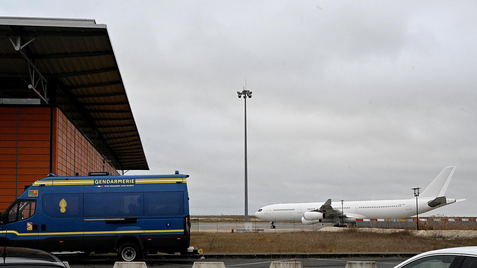 Ein Fahrzeug der Gendarmerie steht vor dem französischen Flughafen Vatry. Im Hintergrund ist ein Flugzeug zu sehen.