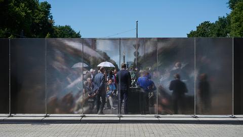 Blick durch die Installation am Brandenburger Tor. Je nach Perspektive wirkt die Wand aus Aluminium lichtundurchlässig oder transparent.