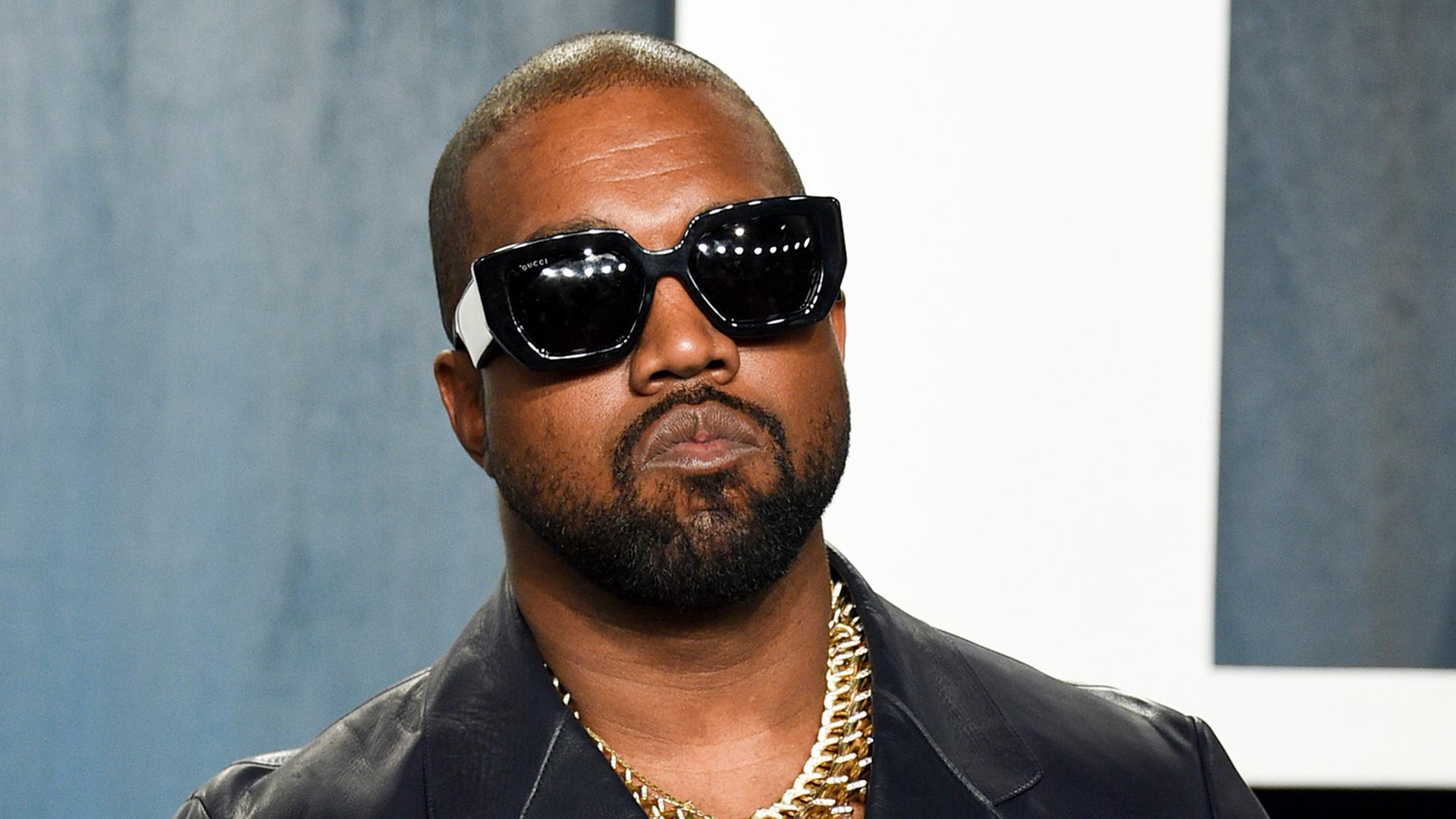 Der Rap-Musiker Kanye West mit einer Sonnenbrille und großen Kette.