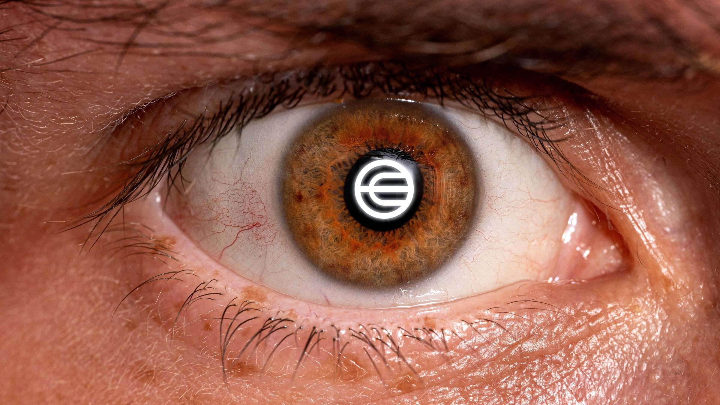 Logo von Worldcoin in der Iris eines menschlichen Auges (Montage, Symbolbild)