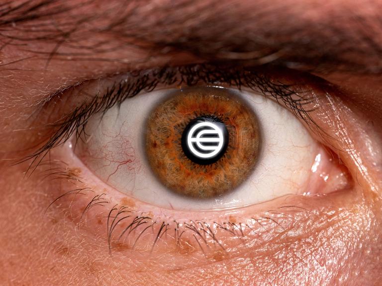 Logo von Worldcoin in der Iris eines menschlichen Auges (Montage, Symbolbild)