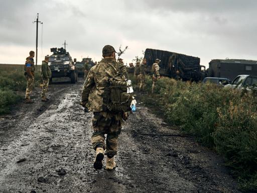 Ukraine, Charkiw: Ukrainische Soldaten stehen auf einer Landstraße in dem befreiten Gebiet in der Region Charkiw. 