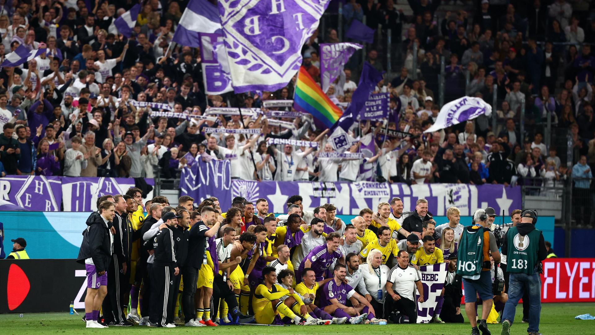 Spieler vom HEBC (lila) und von Dortmund (gelb) stehen nach dem Spiel im Volksparkstadion für ein Gruppenbild zusammen. Spieler vom HEBC (lila) und von Dortmund (gelb) stehen nach dem Spiel im Volksparkstadion für ein Gruppenbild zusammen.