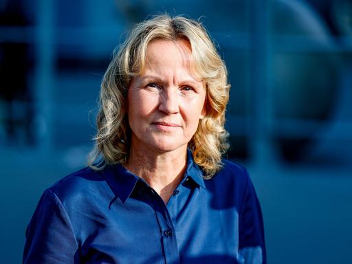 Ein Porträt von Bundesumweltministerin Steffi Lemke (Bündnis90/Die Grünen), blonde Haare, dunkelblaue Bluse vor blauem Hintergrund. 