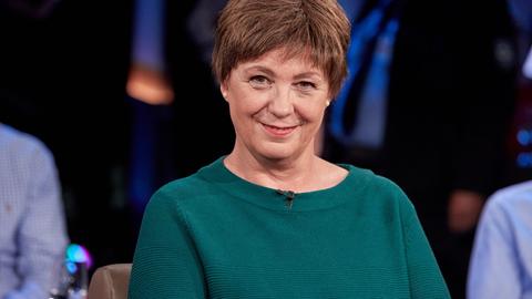 Andrea Krull lächelt in die Kamera. Sie trägt kurzes braunes Haar und einen dunkelgrünen Pullover.