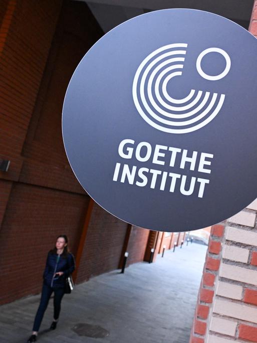 Das Logo des Goethe-Institute ist an einer roten Backsteinwand befestigt.