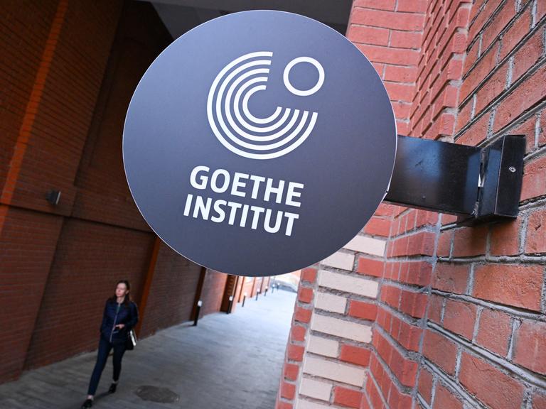 Das Logo des Goethe-Institute ist an einer roten Backsteinwand befestigt.
