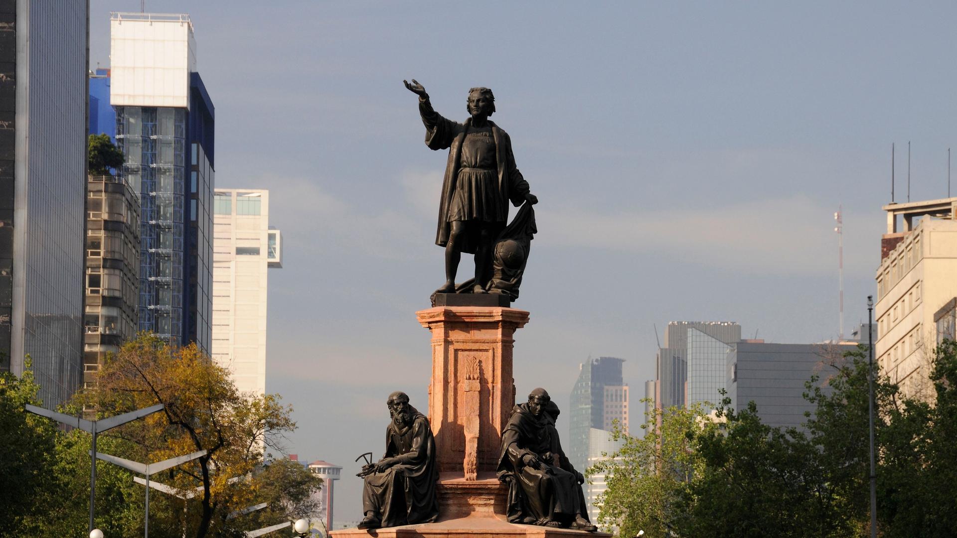 Die Statue des Kolumbus-Denkmals ragt zwischen modernen Bauten in Mexiko-Stadt hervor.