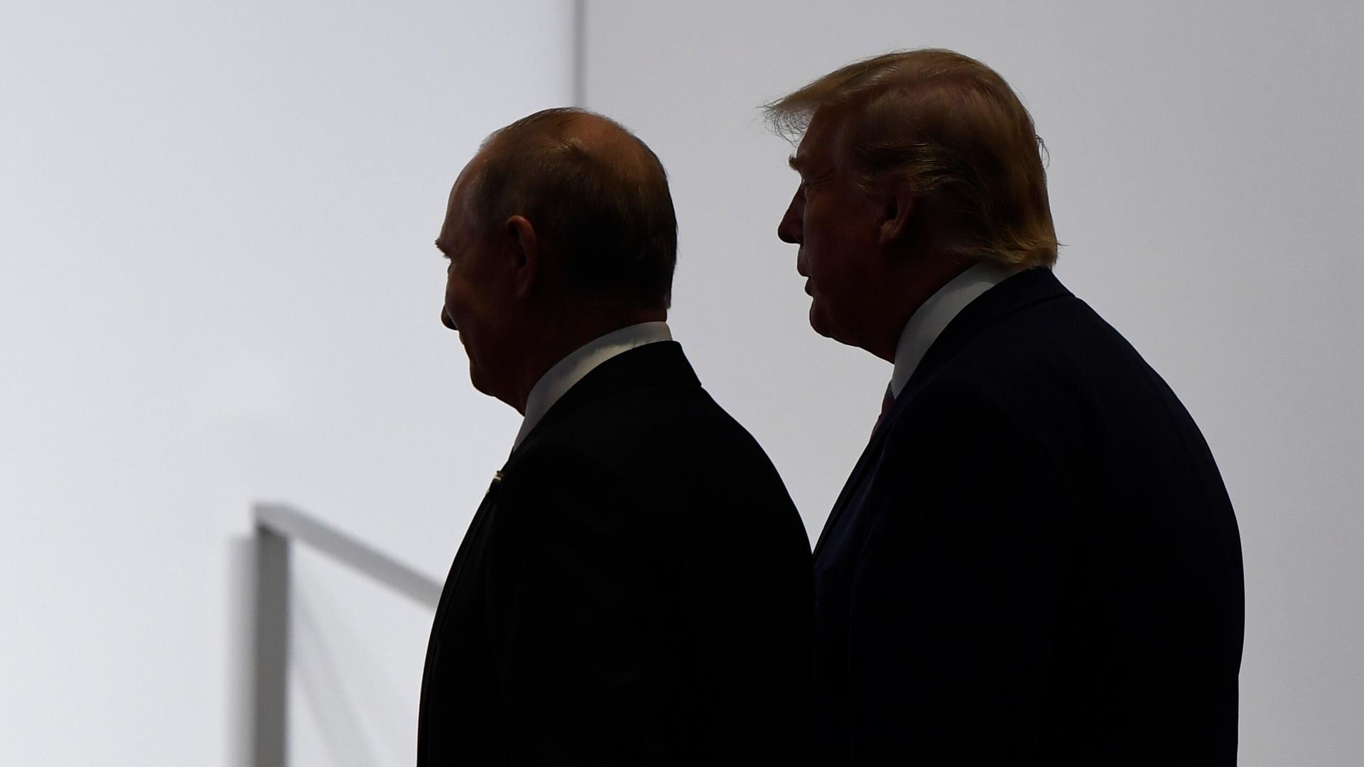 US-Präsident Trump und Russlands Präsident Putin wenden sich gemeinsam zum Gehen, beide sind im Profil und nur im Umriss ihrer Schatten zu erkennen. US-Präsident Trump und Russlands Präsident Putin wenden sich gemeinsam zum Gehen, beide sind im Profil und nur im Umriss ihrer Schatten zu erkennen.