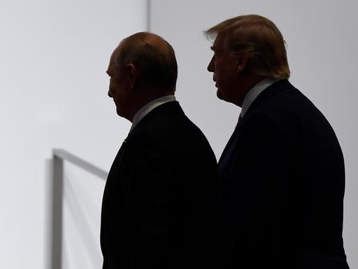 US-Präsident Trump und Russlands Präsident Putin wenden sich gemeinsam zum Gehen, beide sind im Profil und nur im Umriss ihrer Schatten zu erkennen.
