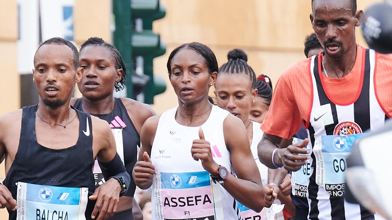 Tigist Assefa (M) aus Ãthiopien läuft zwischen zwei Männern, hinter ihr weitere Läuferinnen.