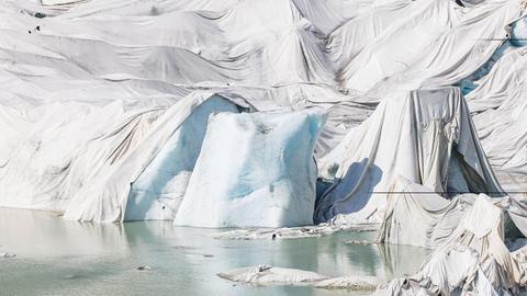 Damit der Rhonegletscher vor der Sonne geschützt ist, wurde der Gletscher mit weissen Tüchern bedeckt. Gemäss Erwartungen soll der Gletscher bis 2100 vollständig geschmolzen sein. Obergoms, Schweiz, 15.07.2022.