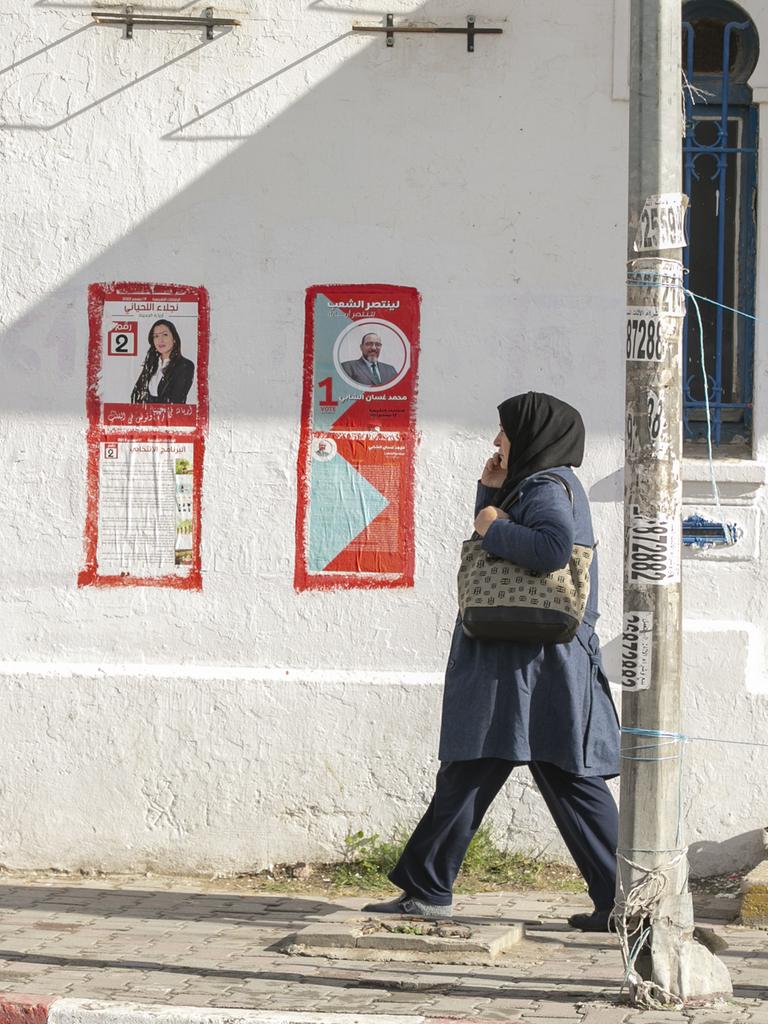 FUßgänger gehen an Wahlplakaten in Tunis vorbi. 