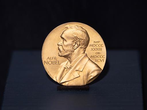 Die Literatur-Nobelpreis-Medaille schräg aufgestellt, steht auf dunkelblauem Grund.