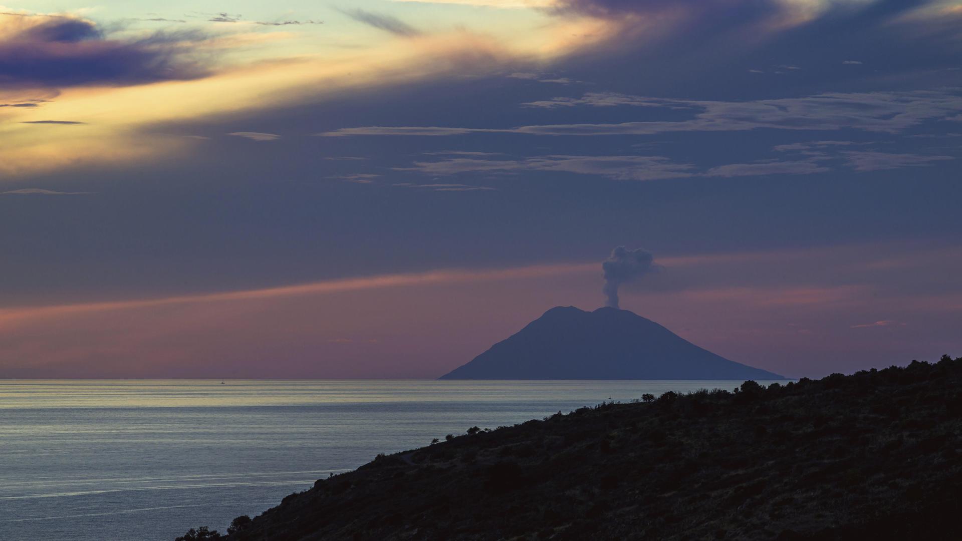 Sonnenuntergang über dem qualmenden Vulkan Stromboli von Nicotera im Tyrrhenischen Meer