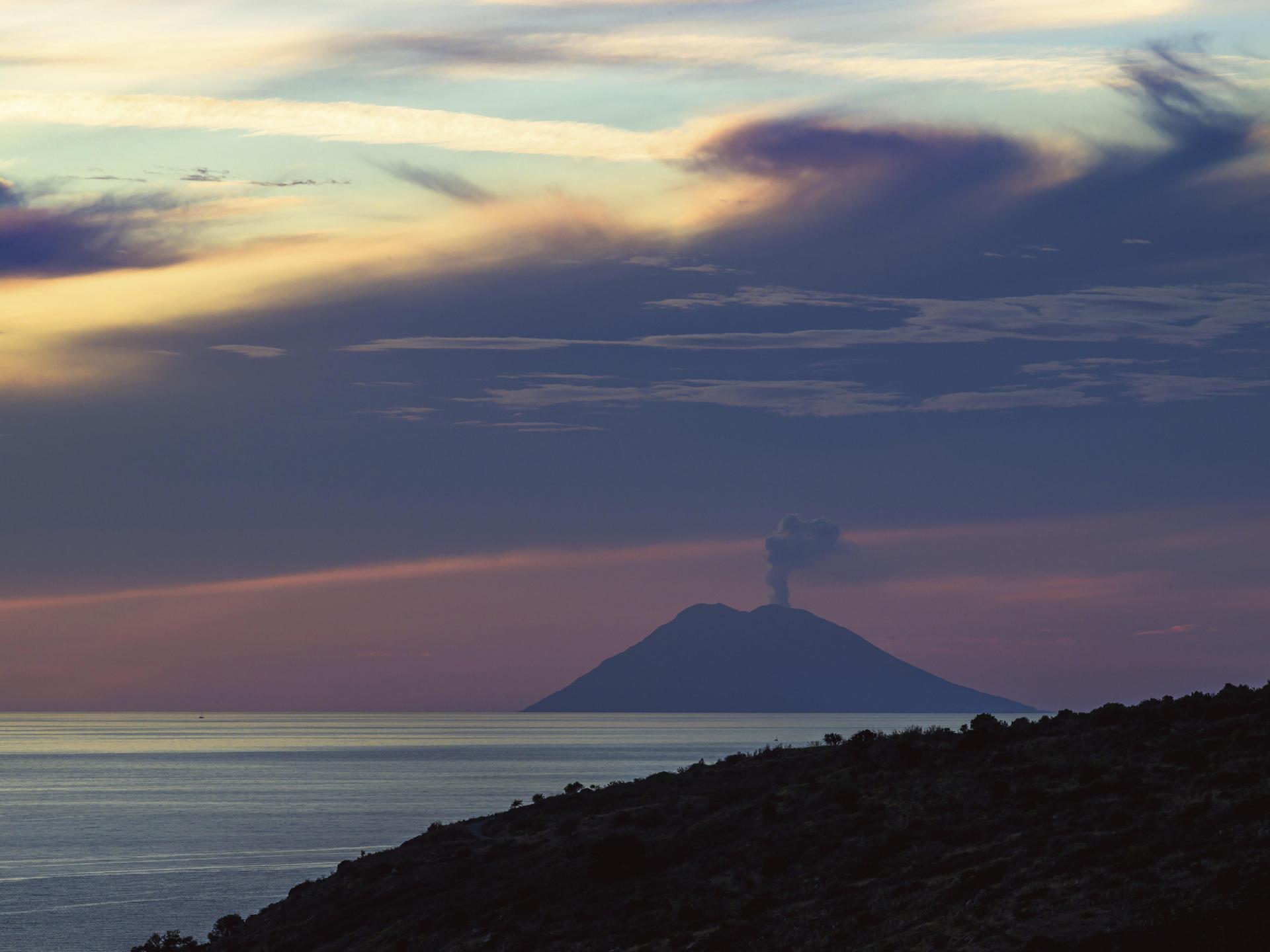 Sonnenuntergang über dem qualmenden Vulkan Stromboli von Nicotera im Tyrrhenischen Meer