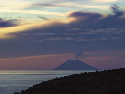Sonnenuntergang über dem qualmenden Vulkan Stromboli von Nicotera im Tyrrhenischen Meer