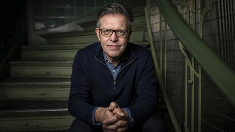 Porträt des Soziologen Steffen Mau, der auf einer Treppe sitzt.