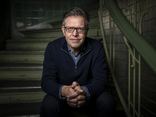 Porträt des Soziologen Steffen Mau, der auf einer Treppe sitzt.