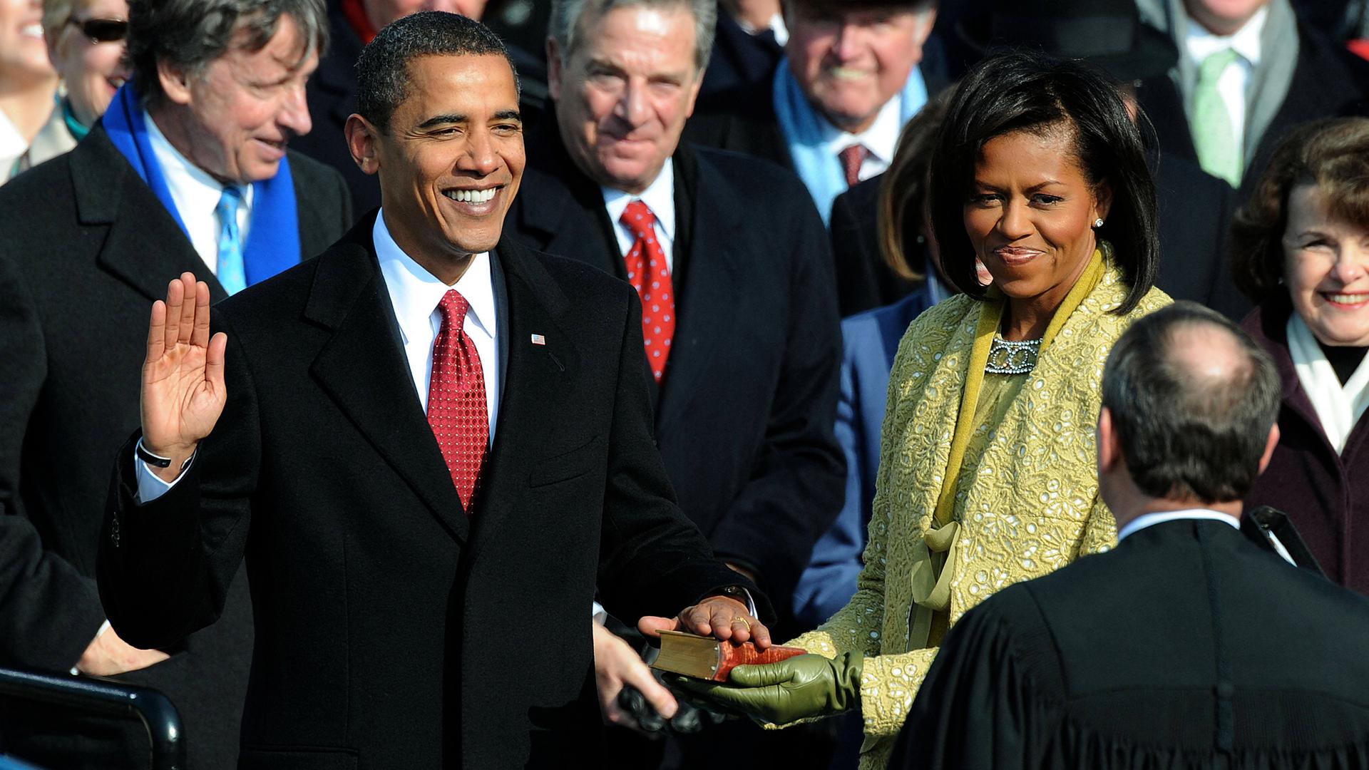 Barack Obama schwört mit einer Hand auf die Bibel bei seiner Amtseinführung 2009 am Kapitol in Washington, seine Frau Michelle Obama hält die Bibel.