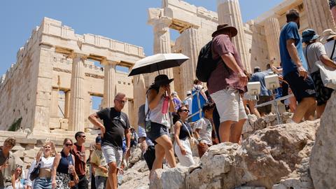 Eine große Gruppe von Touristen spaziert über das Gelände der Akropolis in Athen, der Hauptstadt Griechenlands. Eine große Gruppe von Touristen spaziert über das Gelände der Akropolis in Athen, der Hauptstadt Griechenlands.