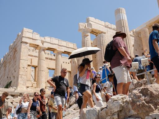 Eine große Gruppe von Touristen spaziert über das Gelände der Akropolis in Athen, der Hauptstadt Griechenlands.