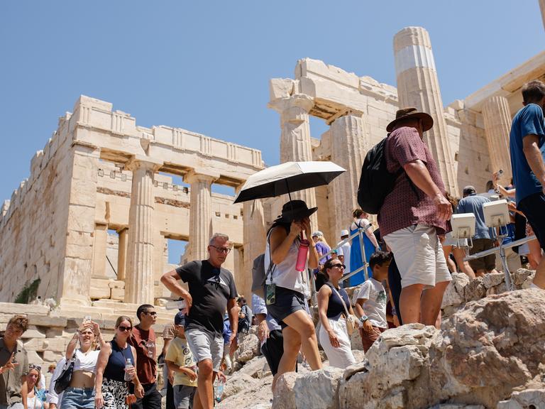 Eine große Gruppe von Touristen spaziert über das Gelände der Akropolis in Athen, der Hauptstadt Griechenlands.